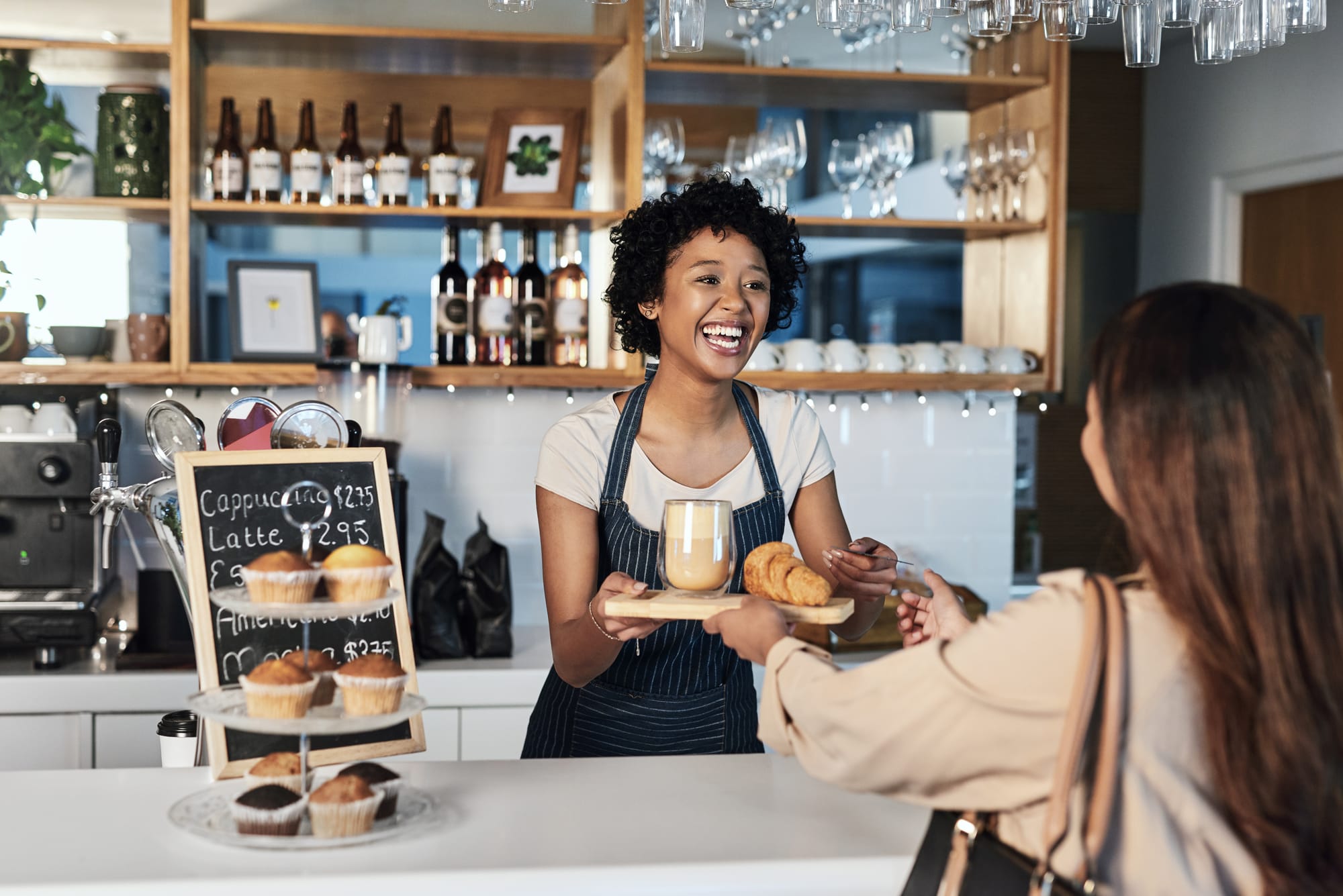 Coffee shop barista serving coffee to guest after searching local seo results on Google.