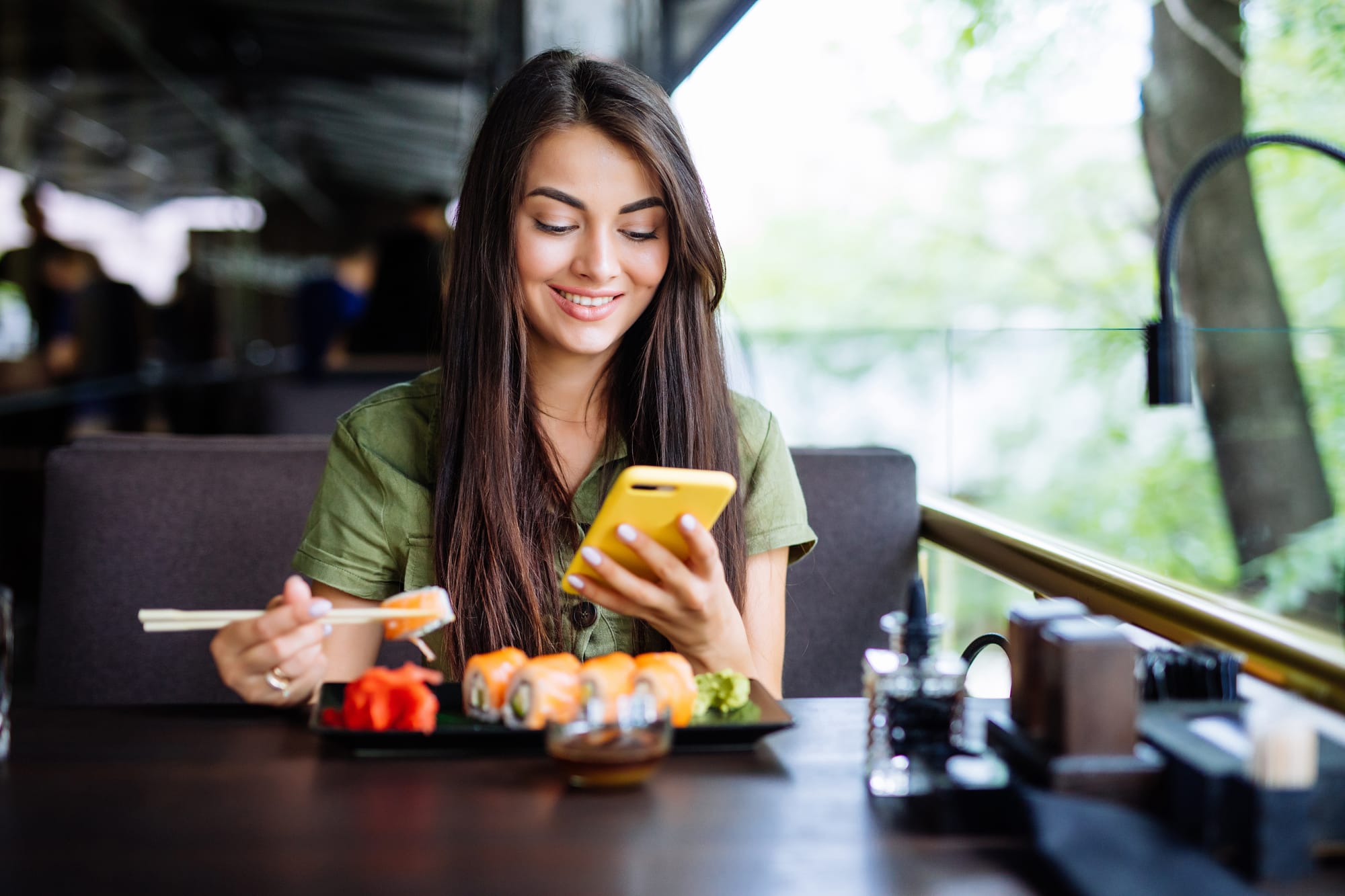 Guest in restaurant eating nigiri sushi and Googling local results thanks to SEO.