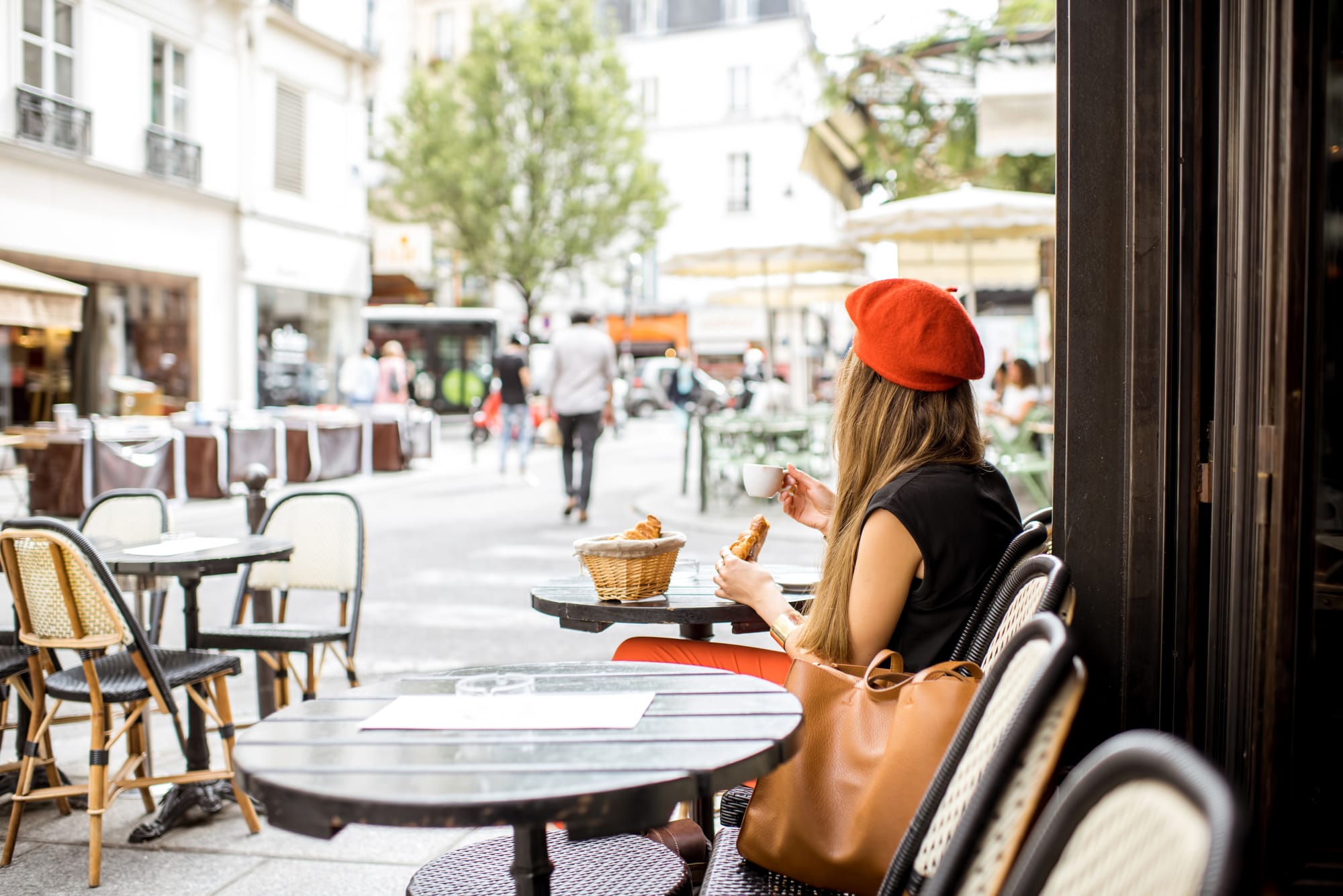 Artist in beret drinking coffee and eating pastries in a coffee shop.