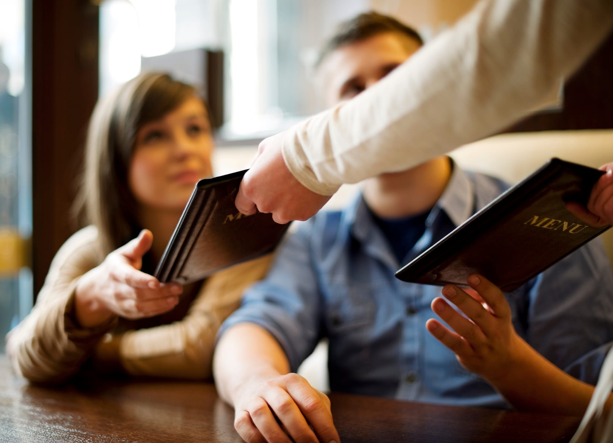 Two guests at a restaurant receive menus with items they found from a local seo search on Google.