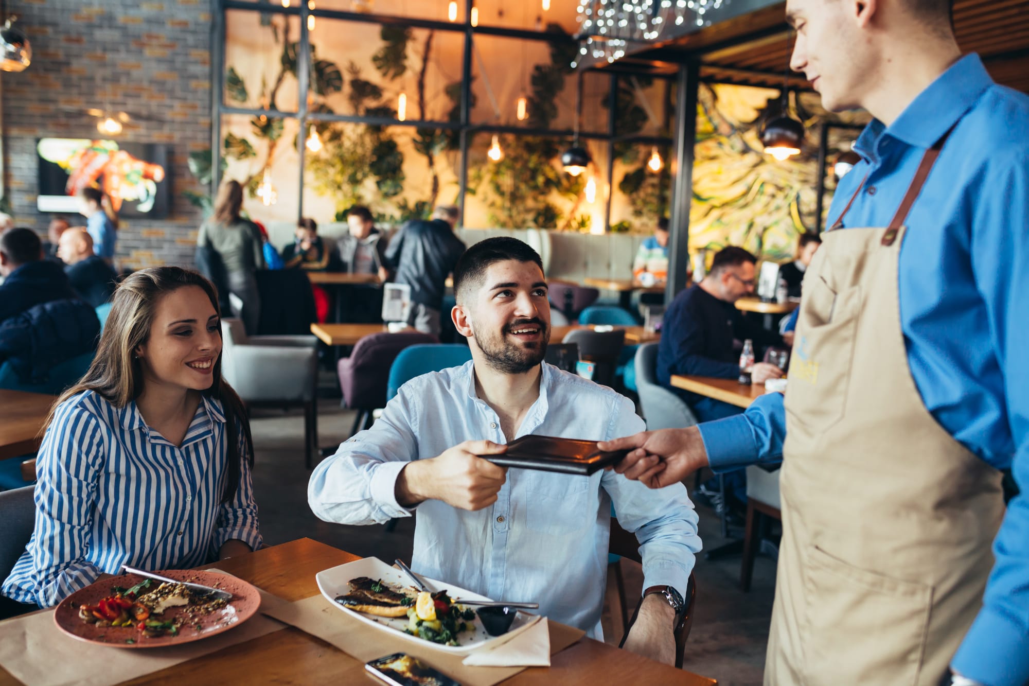 Server hands over the check at a restaurant.