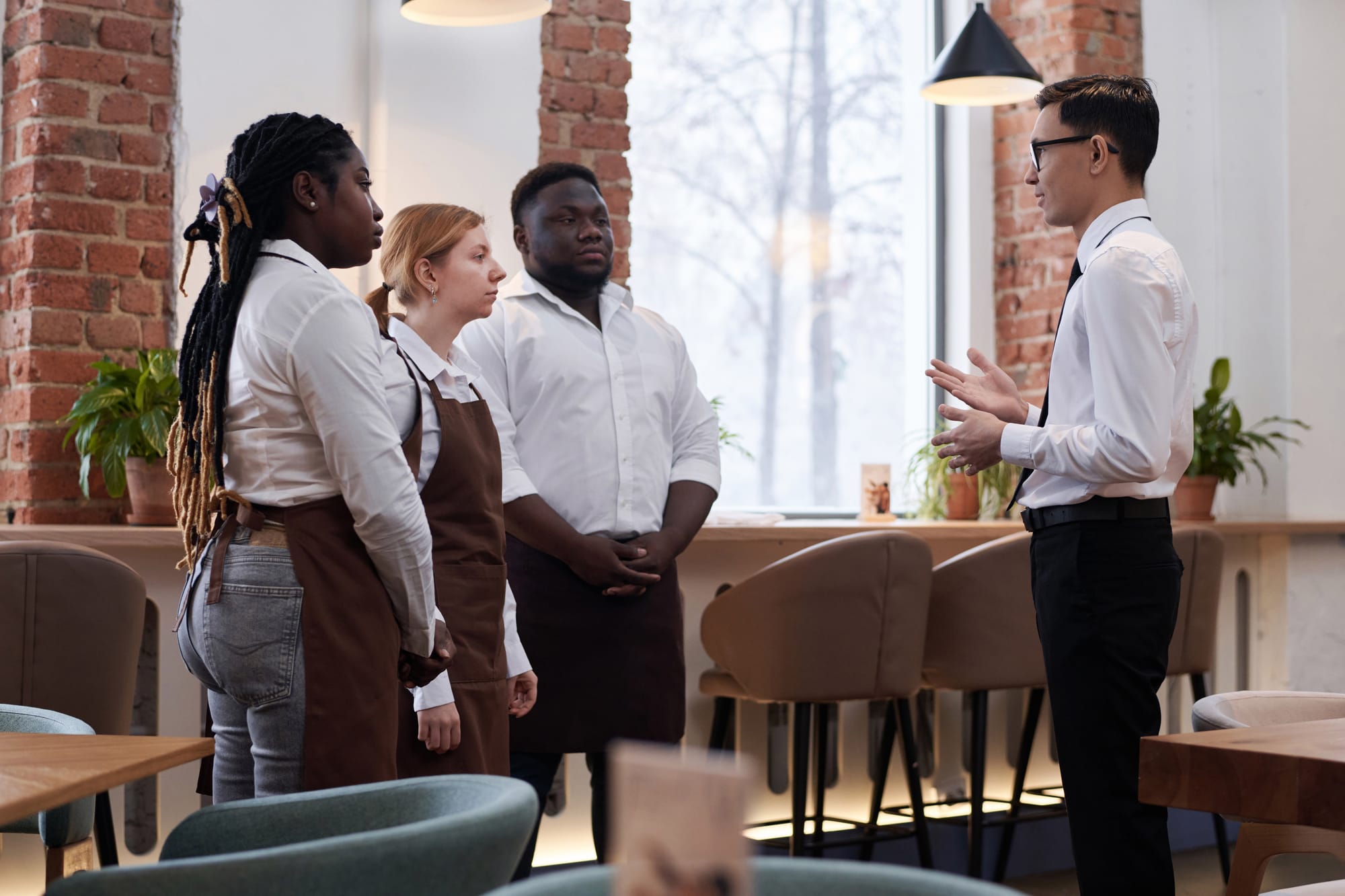 Manager talking to staff in a restaurant.