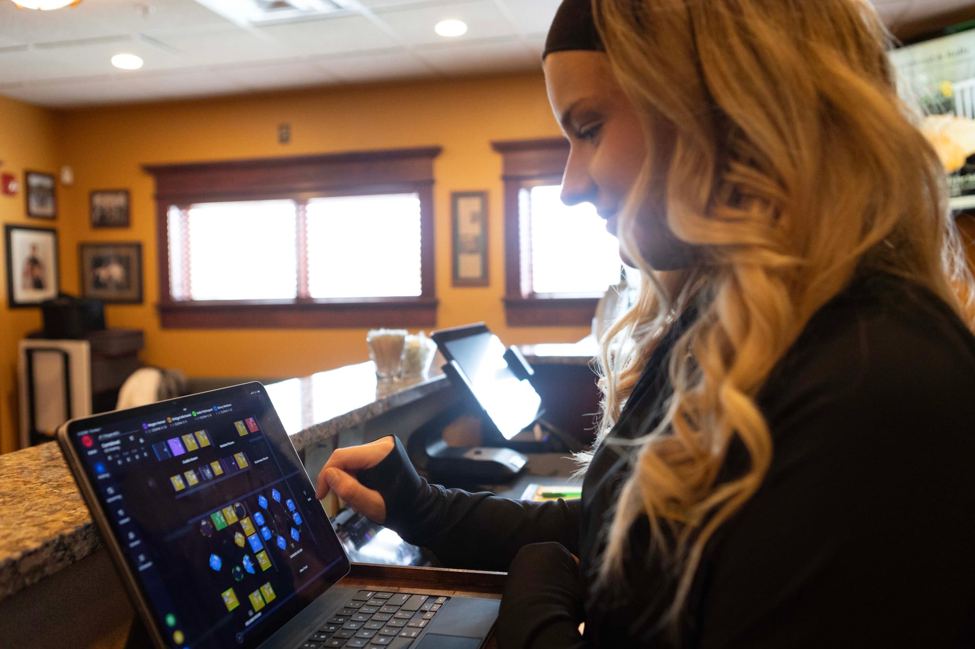 A restaurant host checks table availability on reservation software