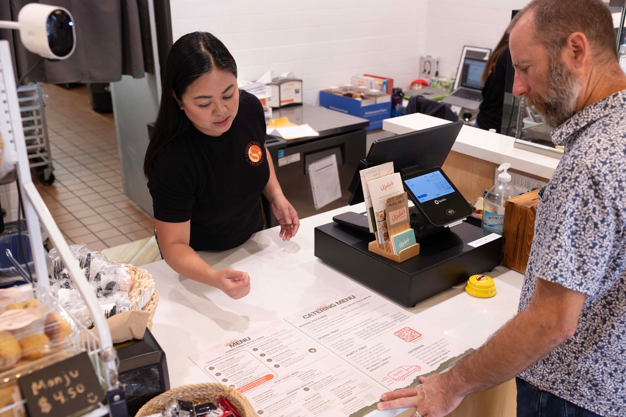 A guest looks at a menu at the counter of a restaurant