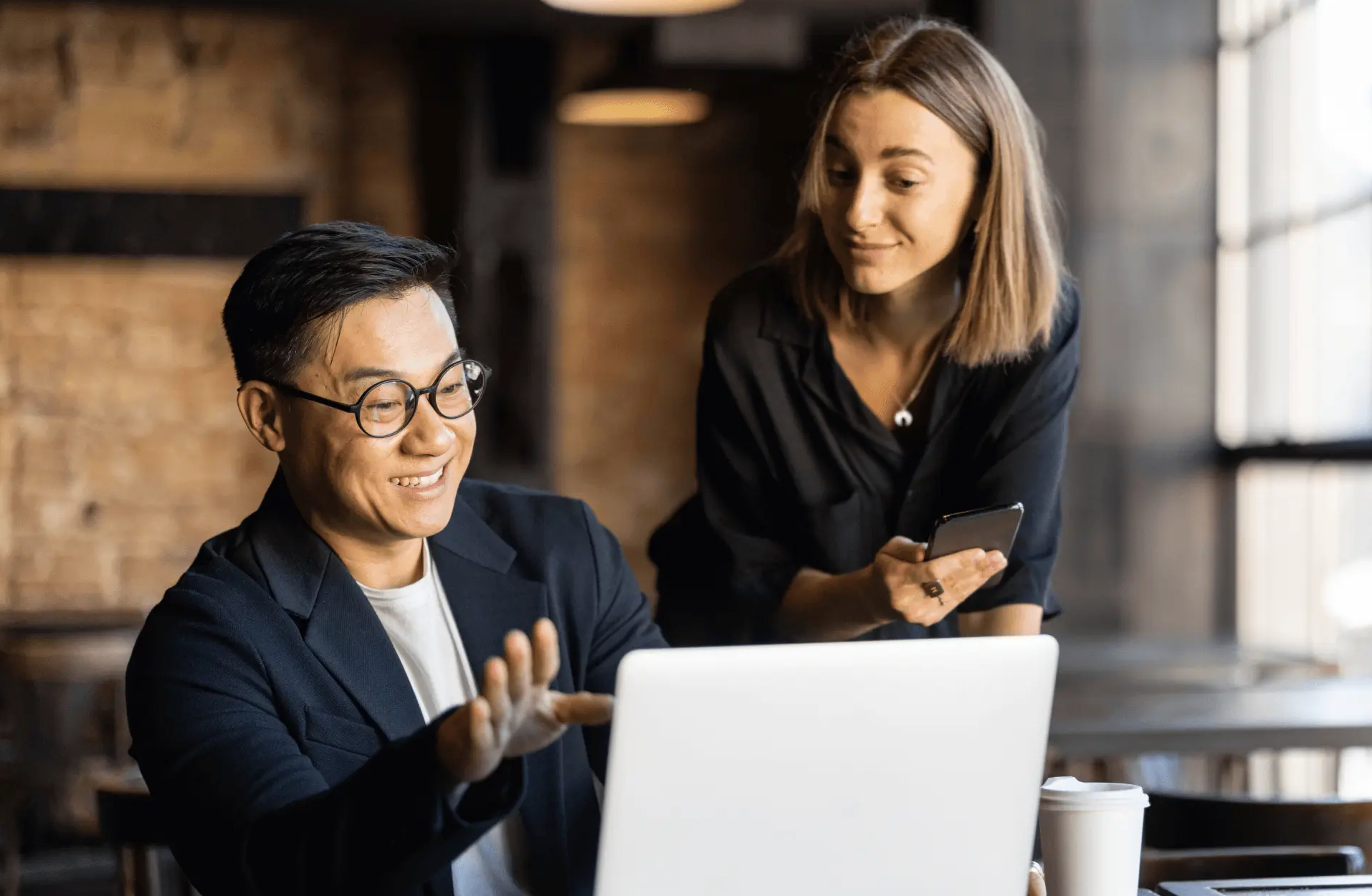 Two restauranteurs marvel over their laptop at the success of their latest marketing campaign.