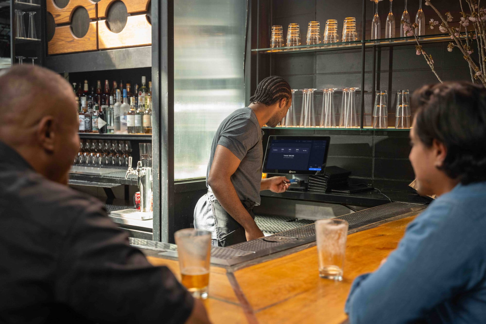 A bartender runs a transaction at the SpotOn brand point-of-sale