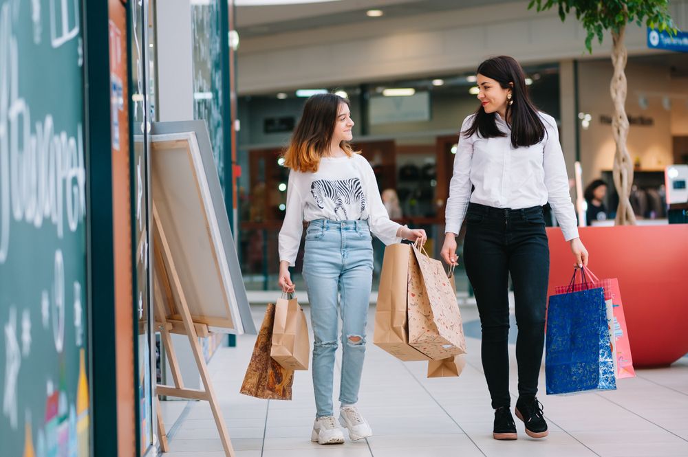 Mother and daughter back-to-school shopping in a mall.