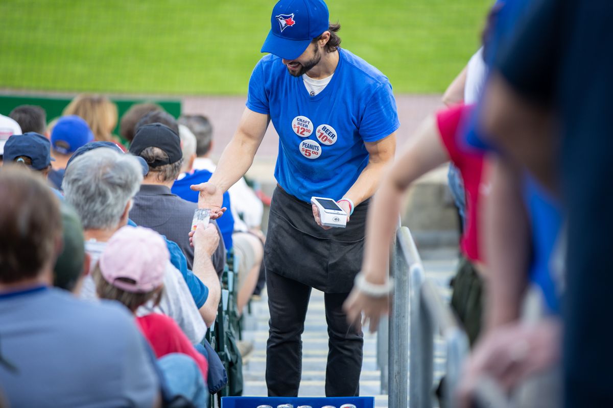 Food vendor at Sahlen Field uses a SpotOn Serve handheld point-of-sale device.