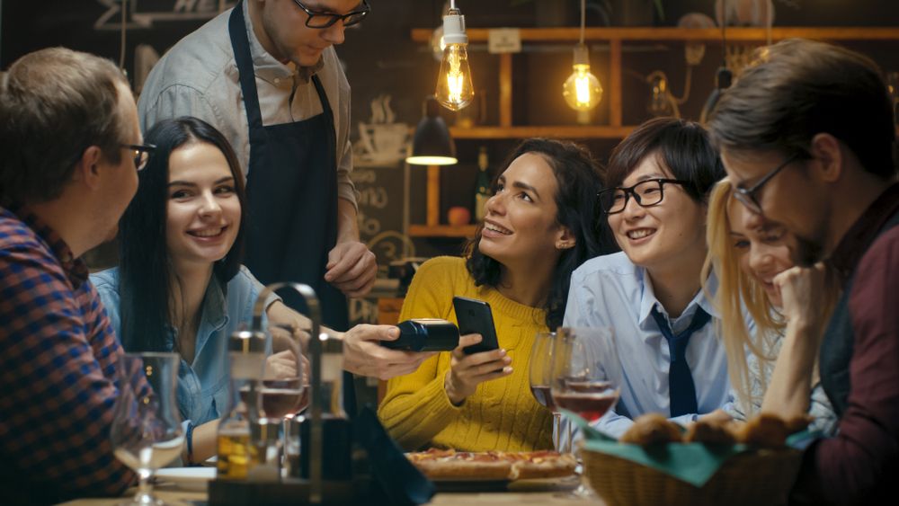 Friends paying for food at a restaurant. 