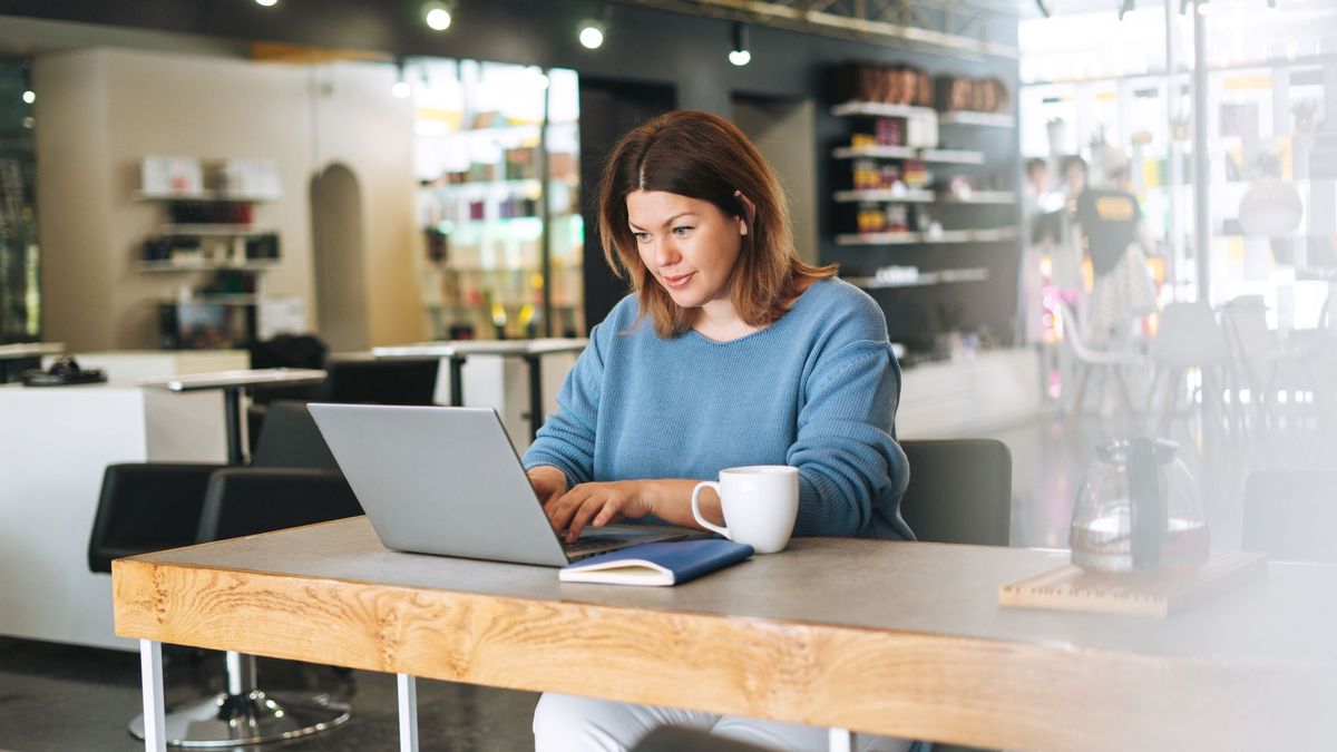 Salon owner researches software solutions on her laptop