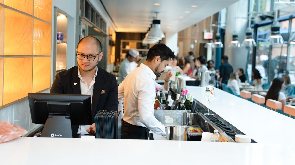 Staff behind the counter ordering from SpotOn POS system, while preparing food orders.