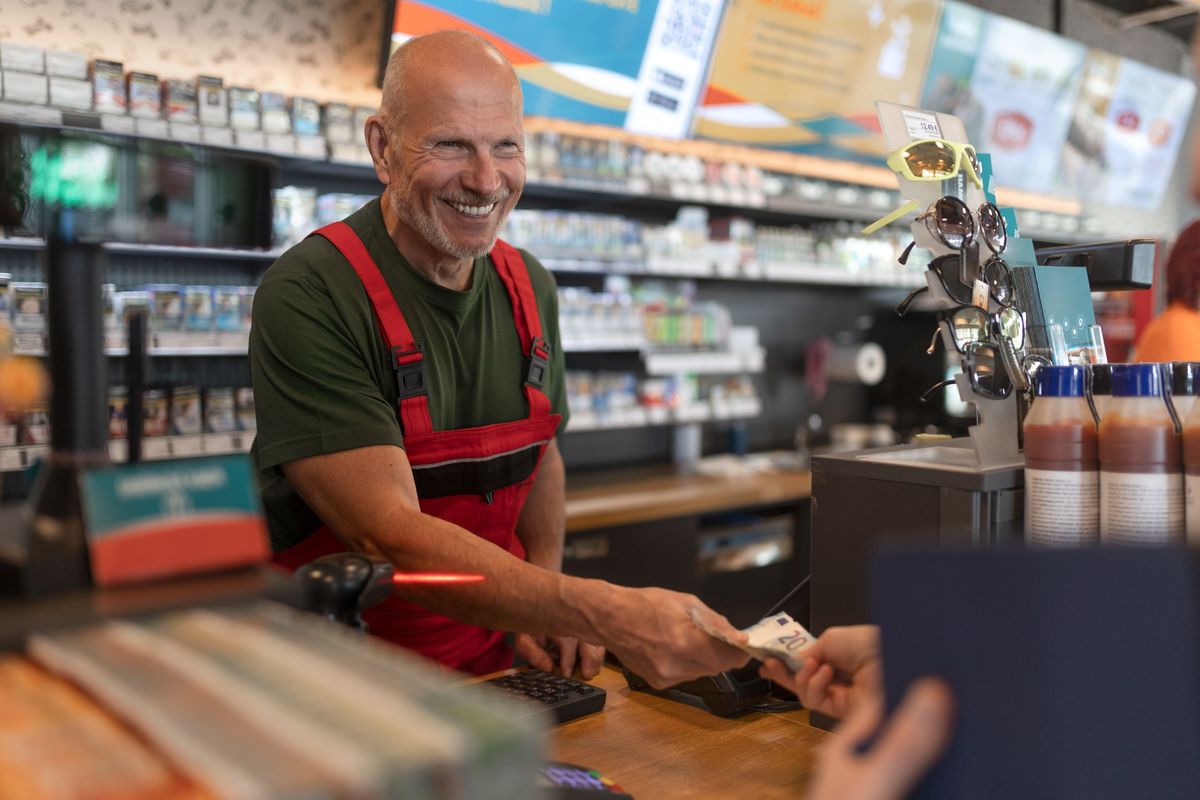 A customer pays with cash at a convenience store