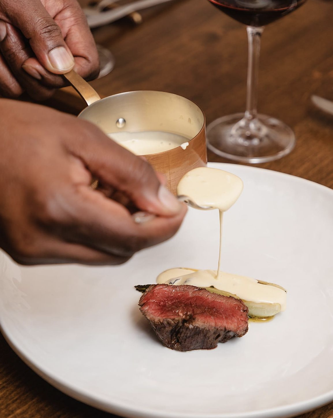 A chef plates a fin-dining steak dinner at Table Culture Provisions