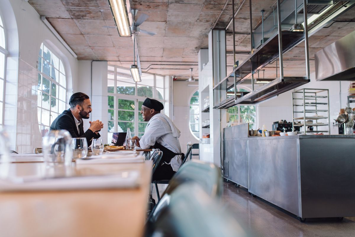 A chef and a restaurant manager discuss their restaurant dream before opening service for guests.