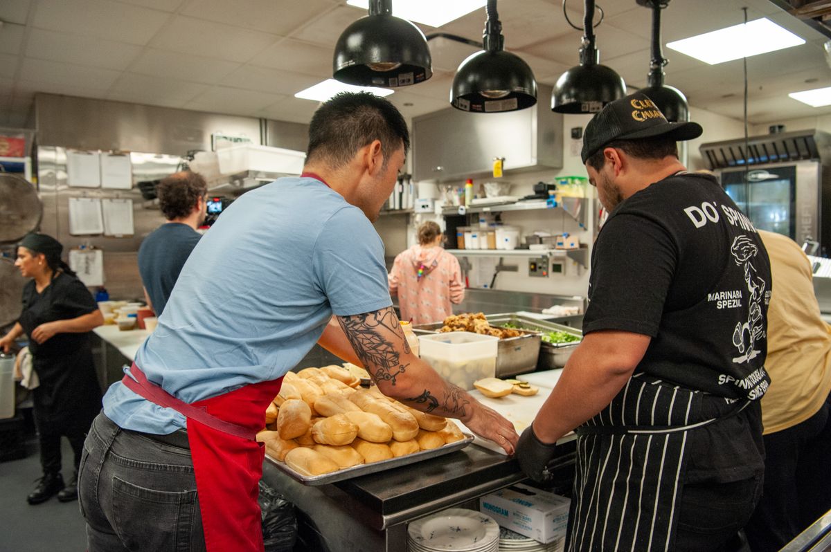 Line cooks prepare food in a restaurant kitchen