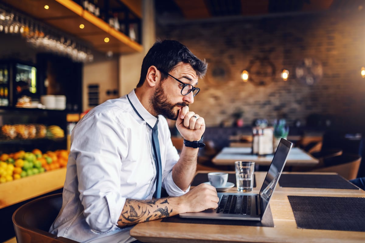 Restaurant manager on a laptop at a table in the restaurant.