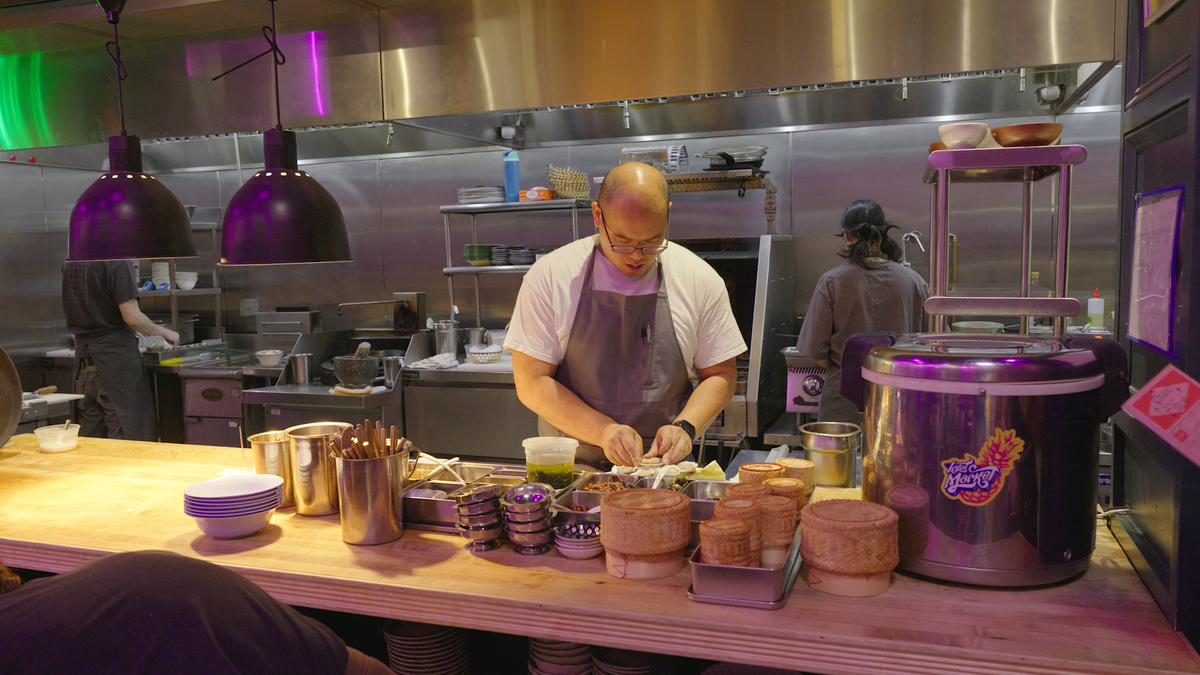 Parnass Savang, co-owner of Talat Market in Atlanta, prepares food in the kitchen.