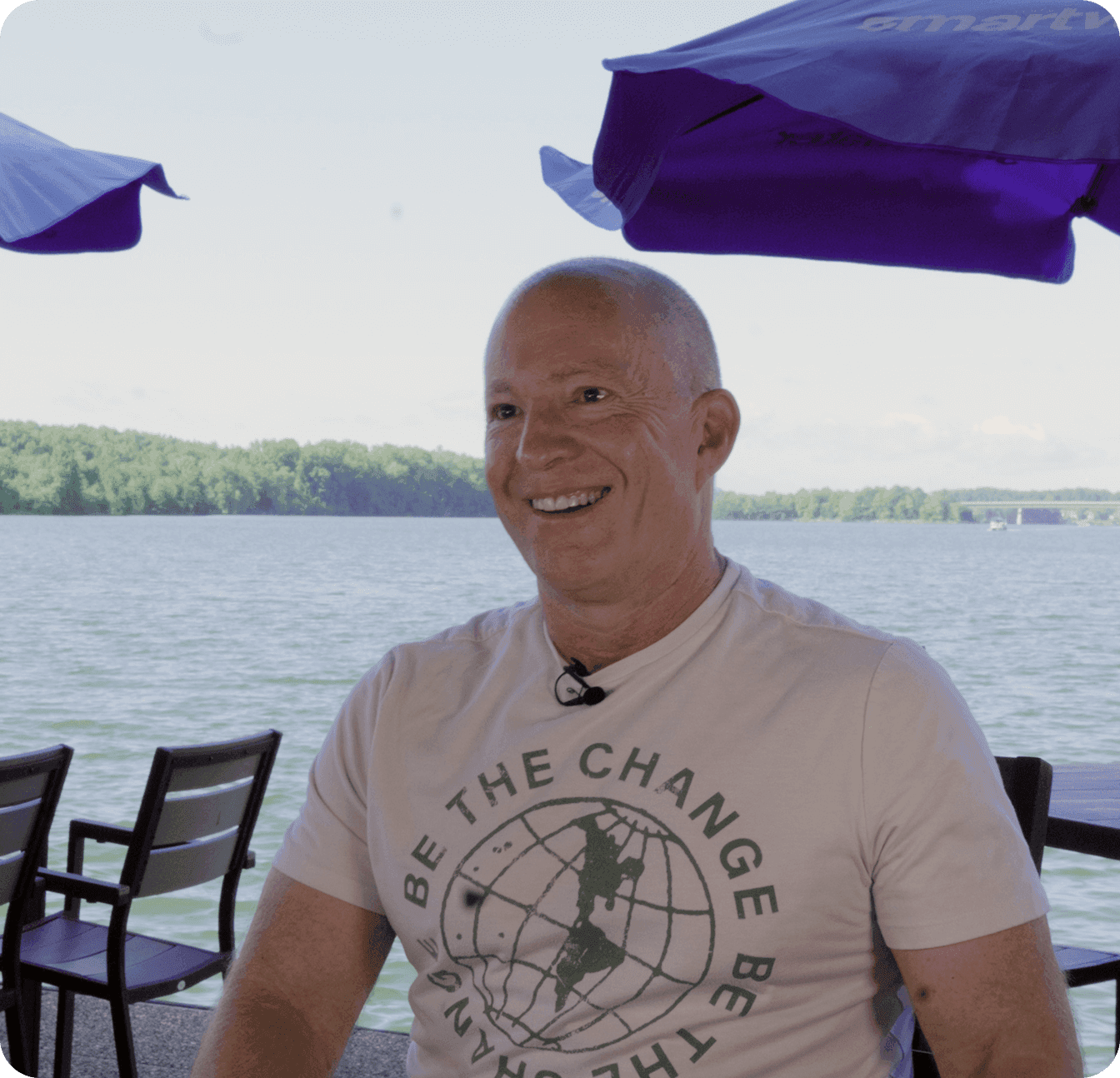Amir Harpaz smiling outdoors at The Mudpuppy restaurant by the lake