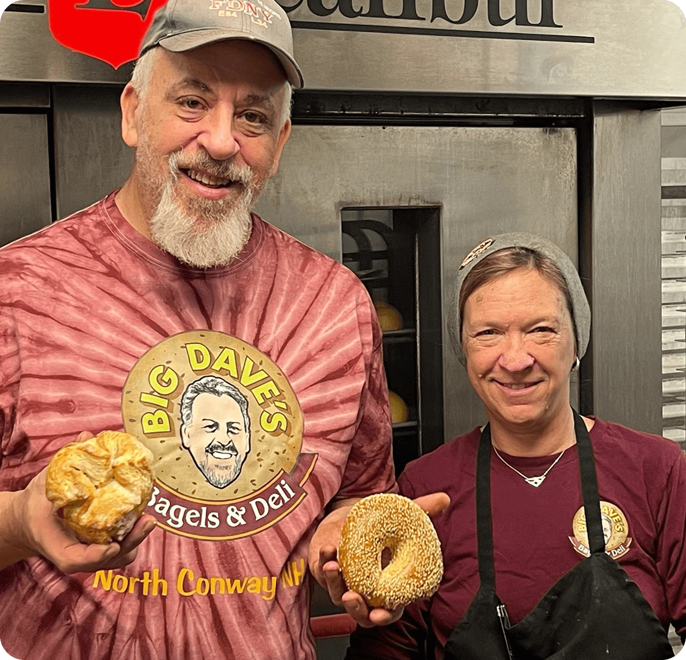 Big Dave’s Bagels & Deli owners smiling and holding fresh bagels