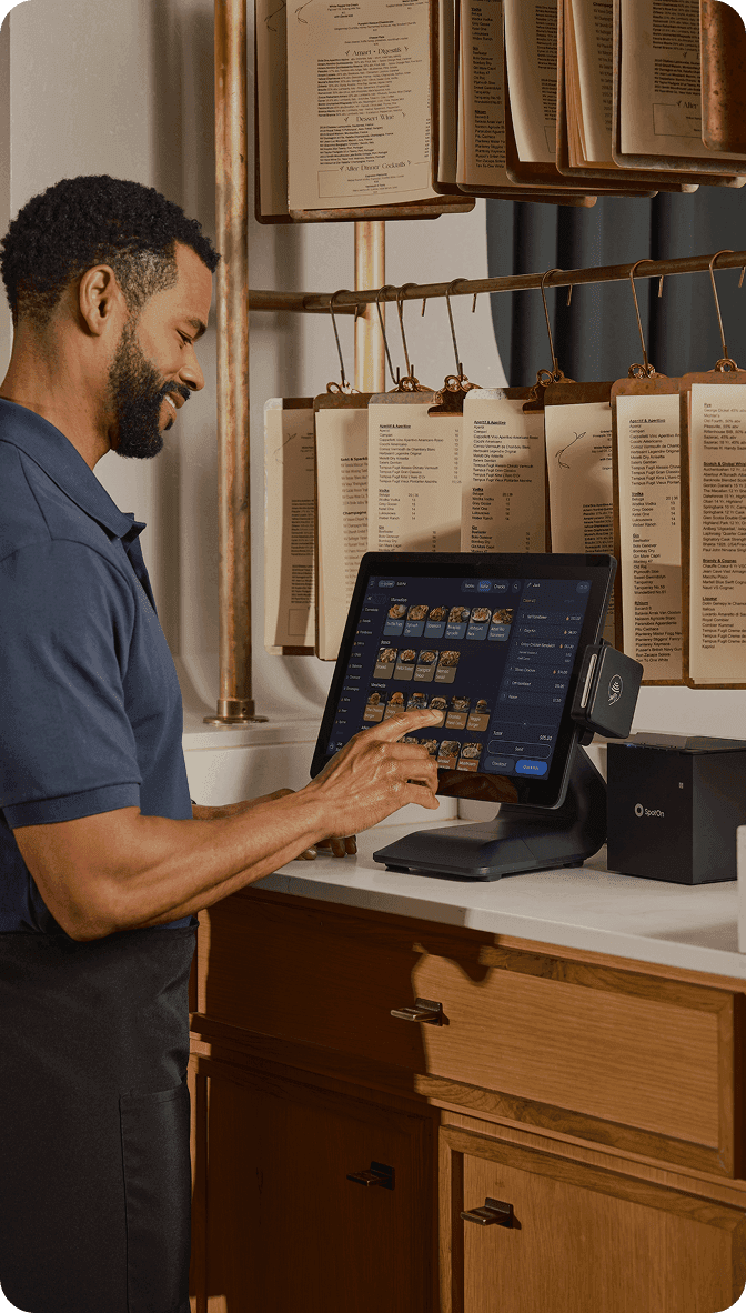 Server processing payment on handheld device in fine dining restaurant