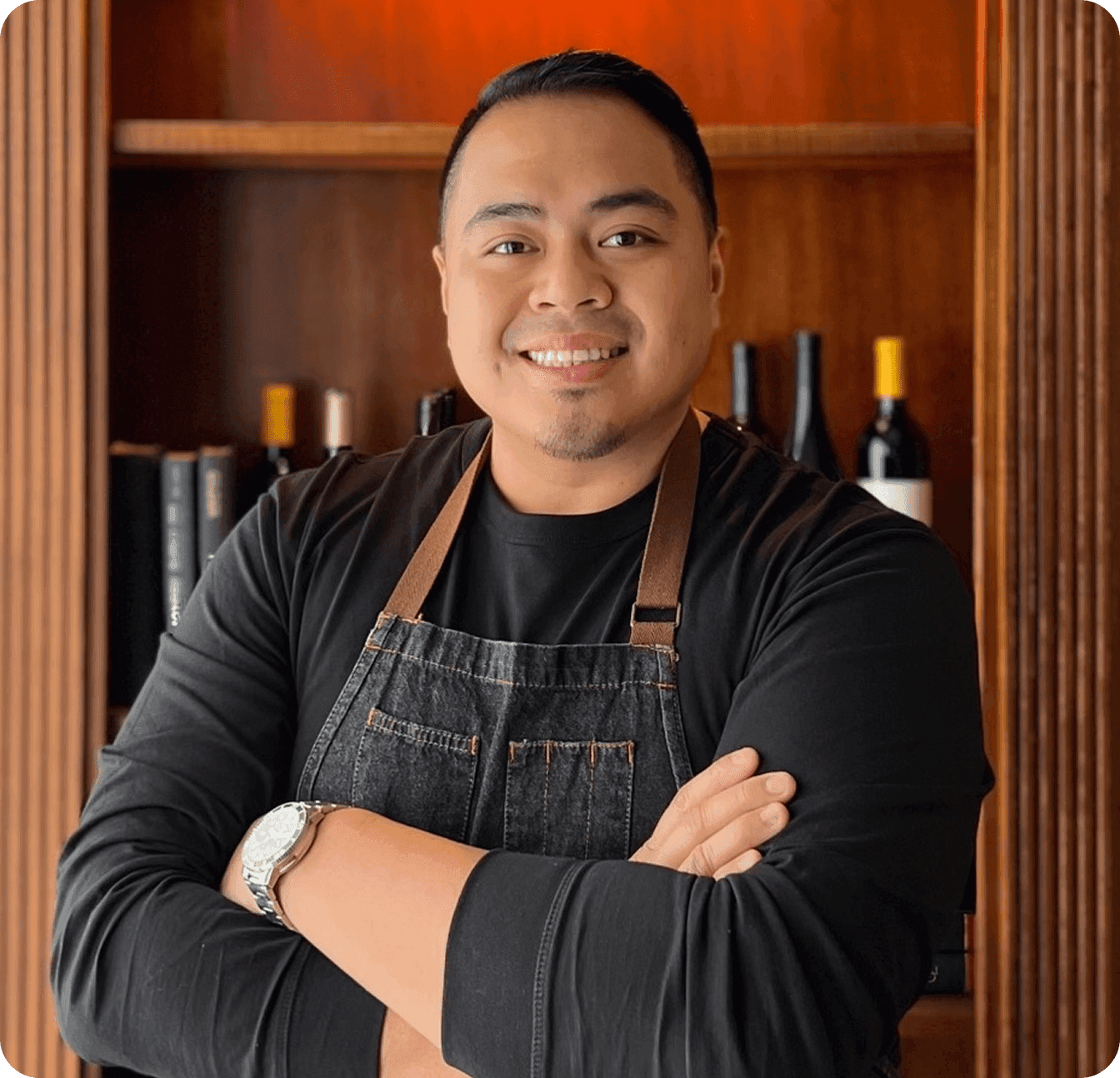 JB Baligit, owner of The Hideout Kitchen, smiling in black apron