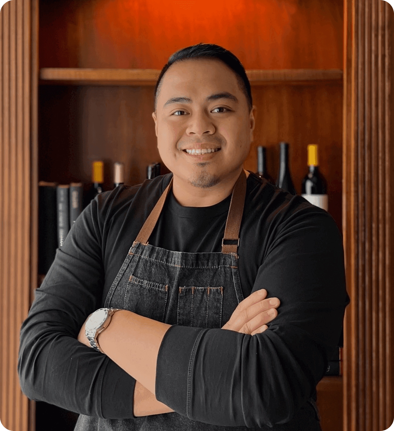 JB Balingit, owner of The Hideout Kitchen, smiling in black apron