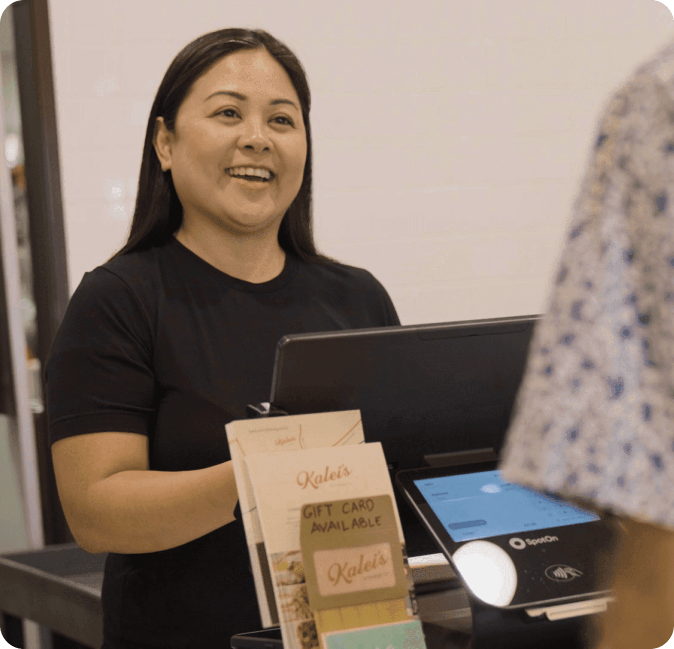 Khara Mangiduyos, owner of Kalei’s Kitchenette, smiling while helping a customer at the counter