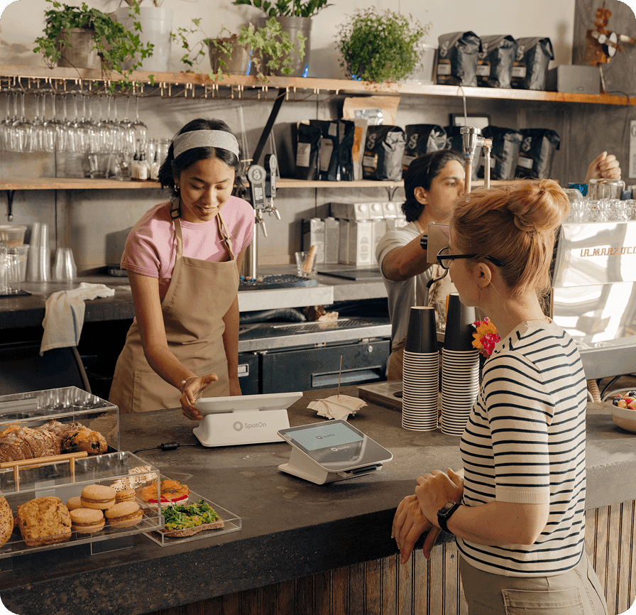 Restaurant manager reviewing staff schedule on laptop at counter
