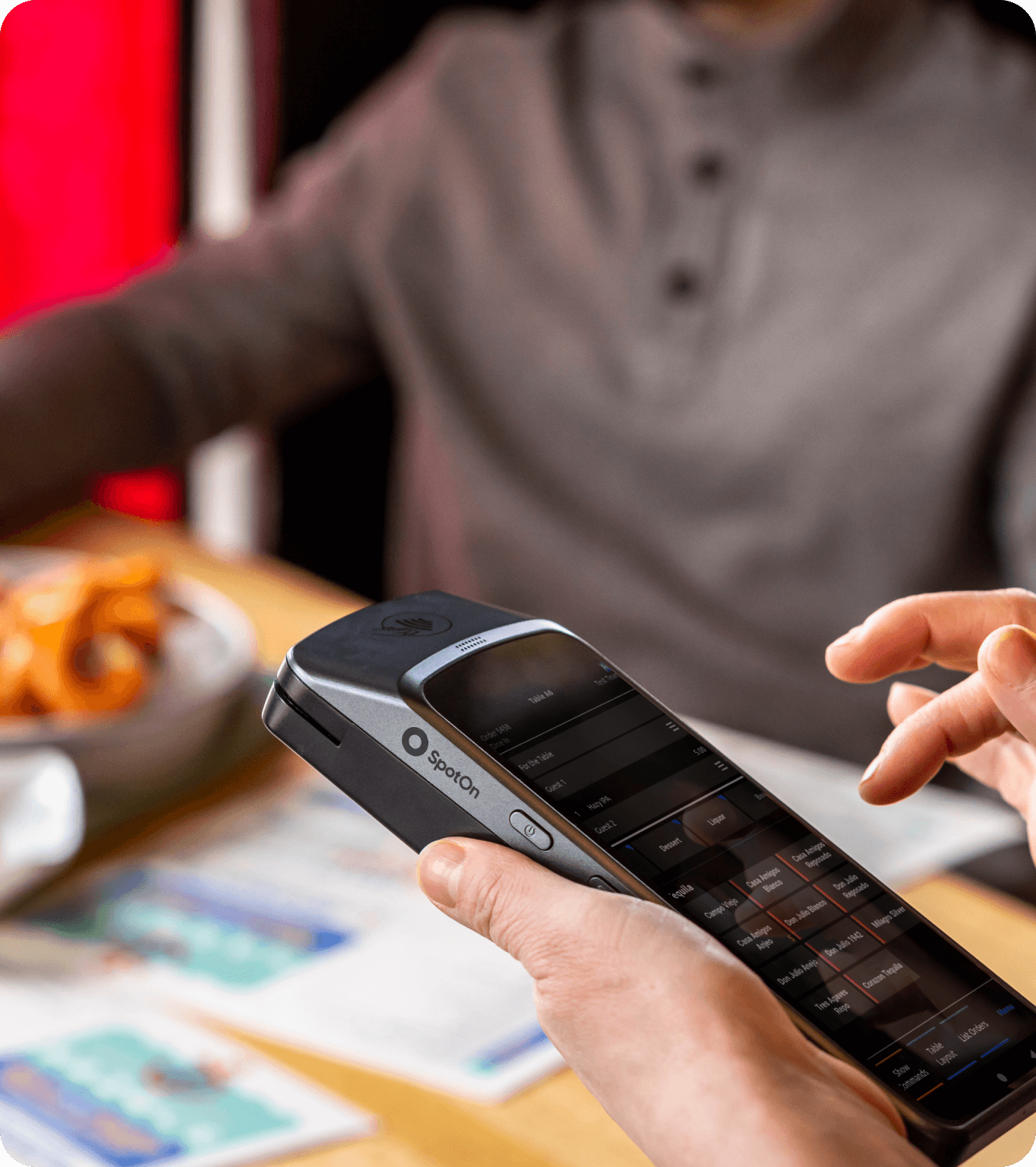 A restaurant customer checks in to earn loyalty points using a handheld POS device