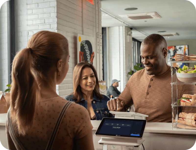 A restaurant customer redeems points on a point-of-sale to earn loyalty rewards at a restaurant