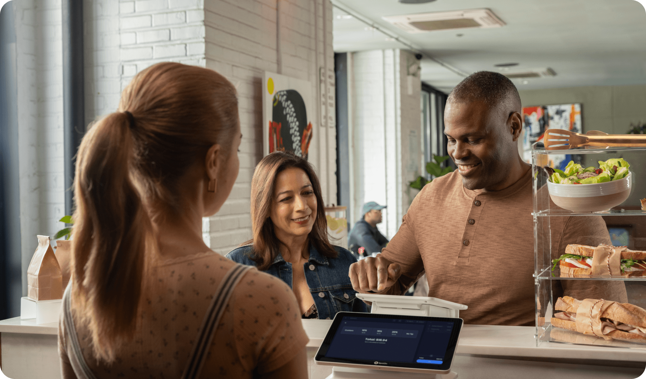 A restaurant customer redeems points on a point-of-sale to earn loyalty rewards at a restaurant