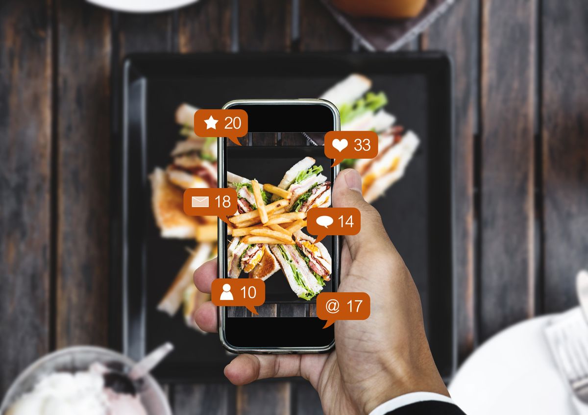 A restaurant operator takes a photo of new dish for social media to help market the restaurant