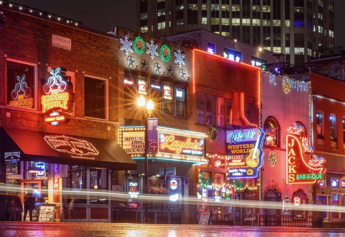Several restaurant storefronts with neon signs in Nashville, TN.